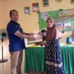 Kepala Desa Lalatezdong Ridwan Maruseng, Sedang Menyerahkan BLT Kepada Warga Pensrimah Manfaat Secara Simbolis di Aula Kantor Desa Jum'at. 15 Mei 2025