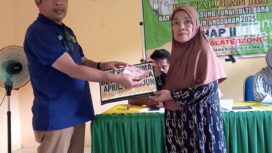 Kepala Desa Lalatezdong Ridwan Maruseng, Sedang Menyerahkan BLT Kepada Warga Pensrimah Manfaat Secara Simbolis di Aula Kantor Desa Jum'at. 15 Mei 2025